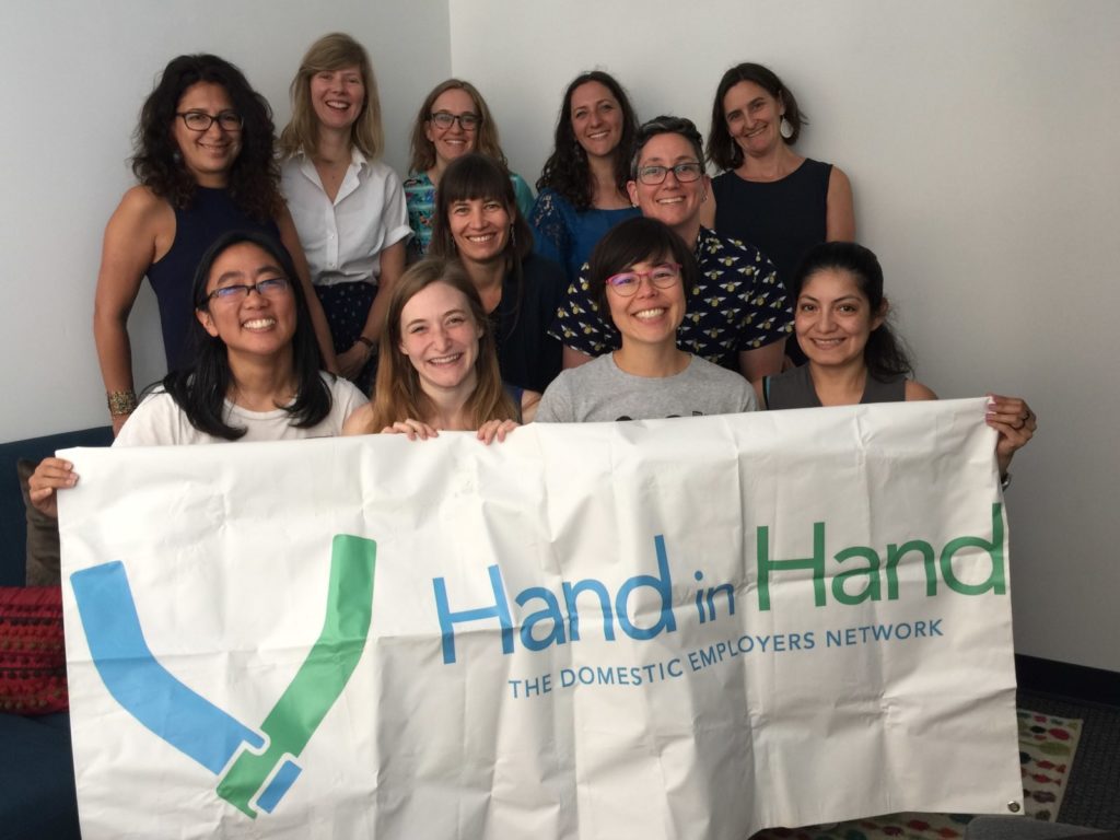 Image of Hand in Hand Staff Holding a Banner that reads Hand in Hand
