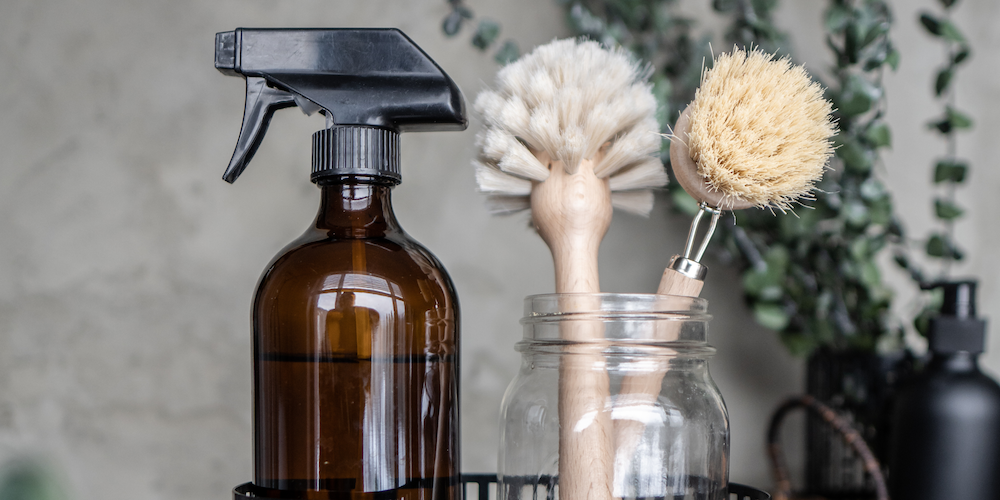 spray bottle and wooden scrub brushes in jar