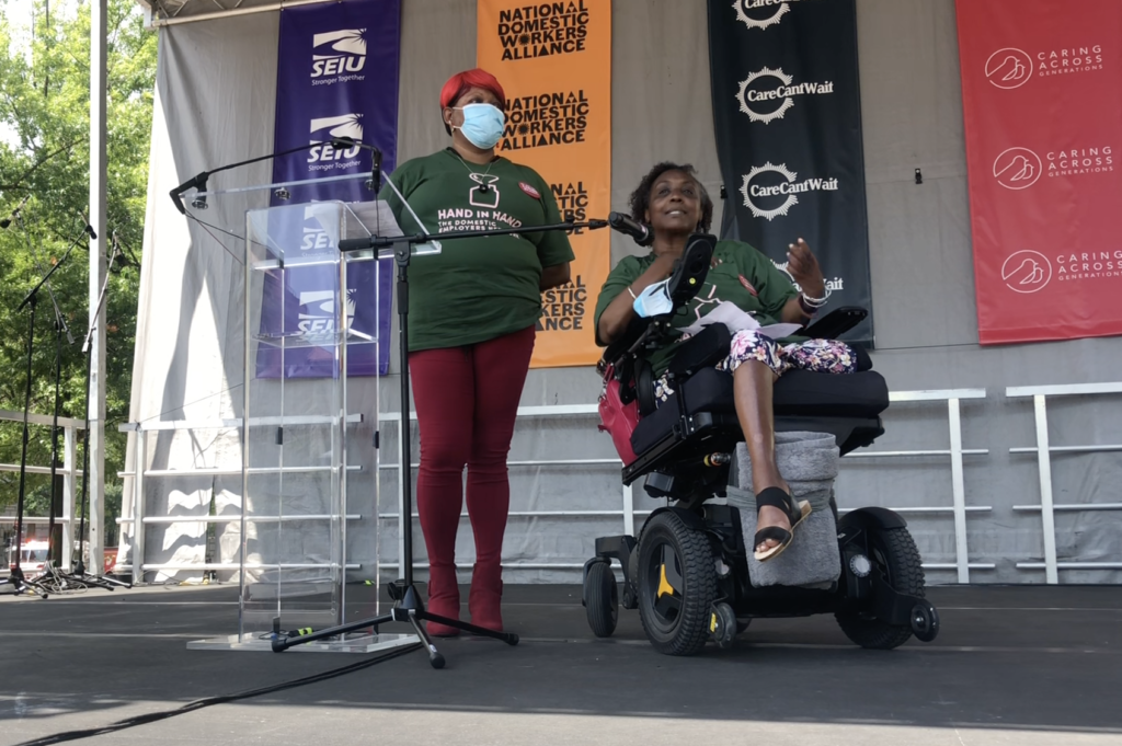 Engracia Figueroa sits in her wheelchair speaking at the Care Cant Wait Mobilization