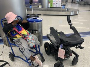 Engracia Figueroa sitting in airport next to broken power chair