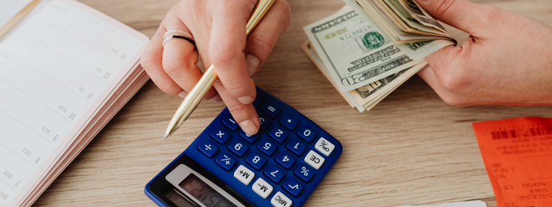 hand holding pen typing calendar with money