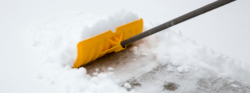 A yellow shovel, on top of white snow