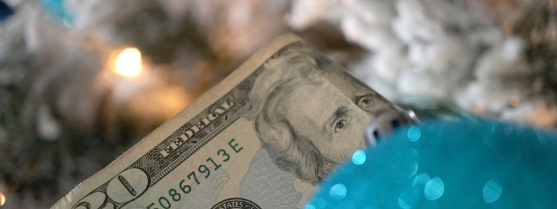 A 20-dollar bill in front of blurry Christmas lights. 