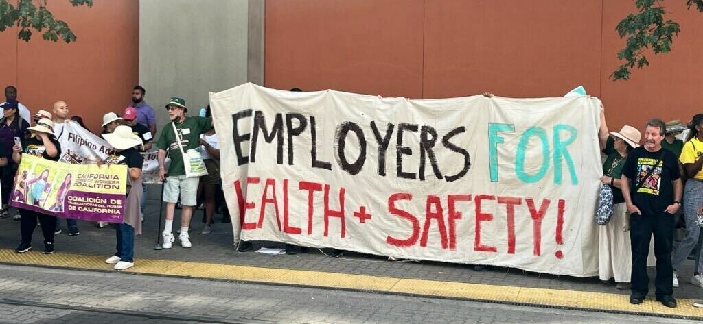 people holding sign that a reads Employers for Health and Safety