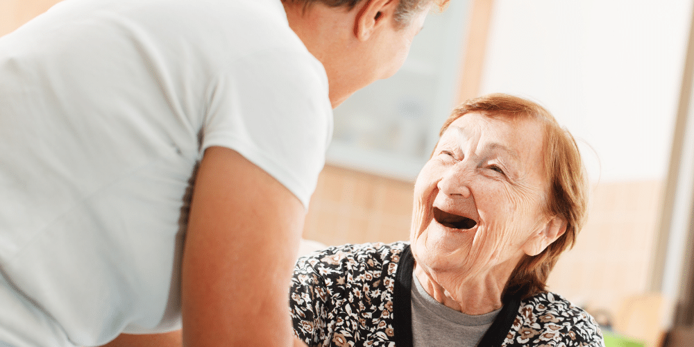 Image of older white woman smiling and looking up at younger white woman woman 