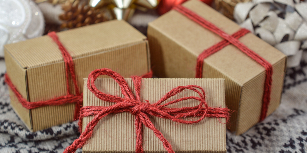 A brown cardboard gift box tied with a red yarn ribbon. 