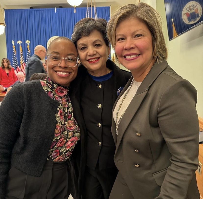 Jenn Stowe of the National Domestic Workers Alliance, Narbada Chetri of Adhikaar and Dr Patricia Campos-Medina smiling as they pose for a photo together.]