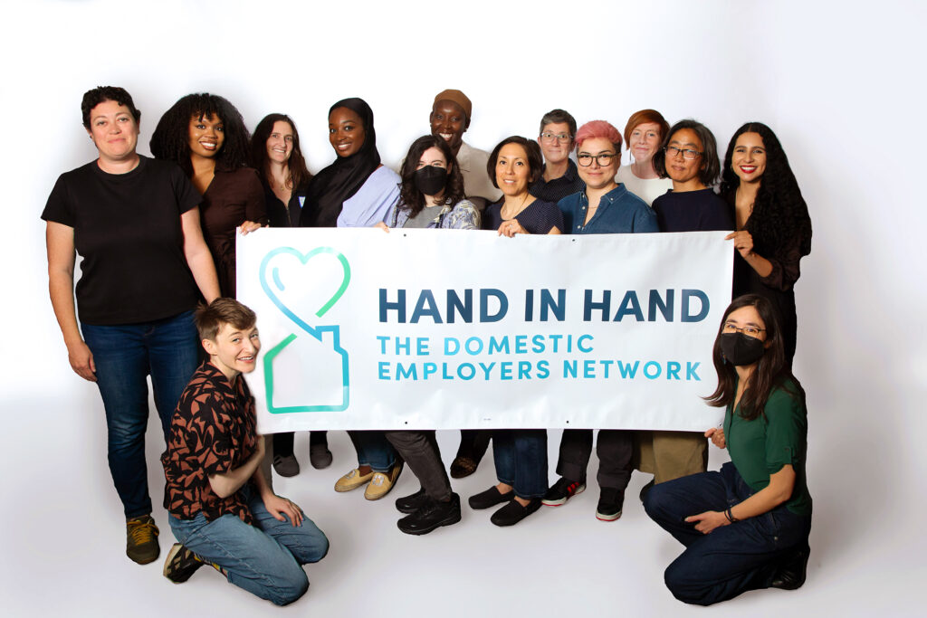 Hand in Hand group staff photo, with Hand in Hand banner.