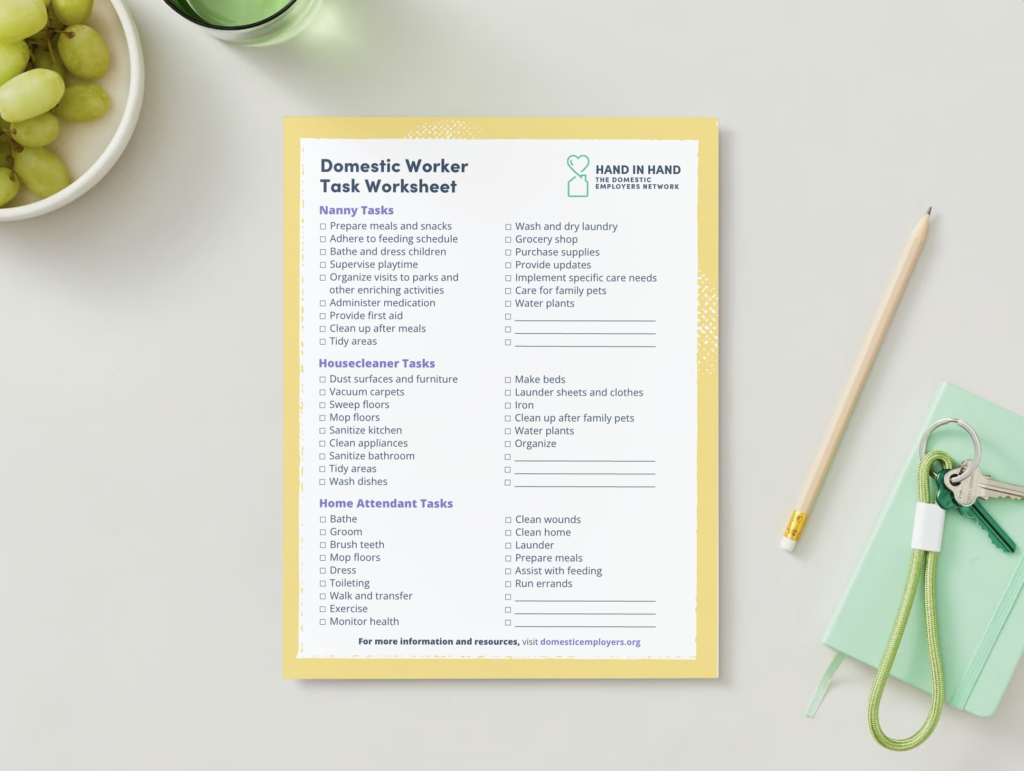 Hand in Hand's Domestic Worker Task Worksheet is a checkbox list of duties nannies, housecleaners, and home attendant workers can perform. The document rests on a white table surrounded by a pencil, light green journal, a green glass cup, and a bowl of green grapes.